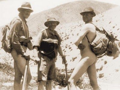 3 bergbeklimmers, waarvan 1 zonder kleren, die liggen te drogen