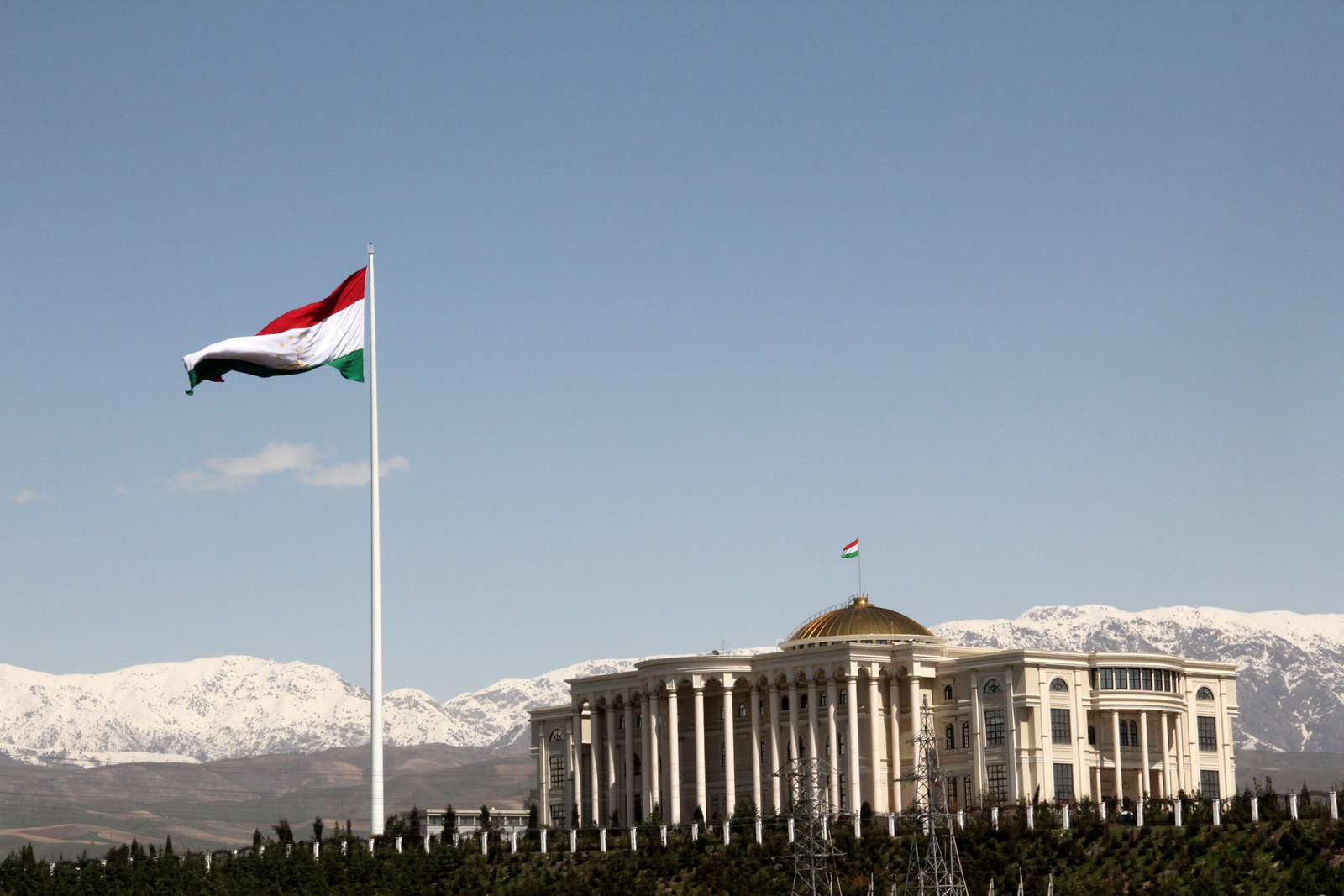 Tajikistan vlaggemast met sneeuwbergen op de achtergrond